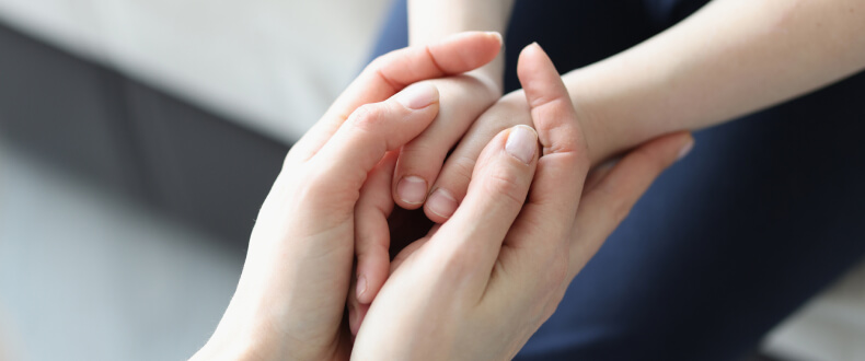Close-up of parent's hands holding child's hands