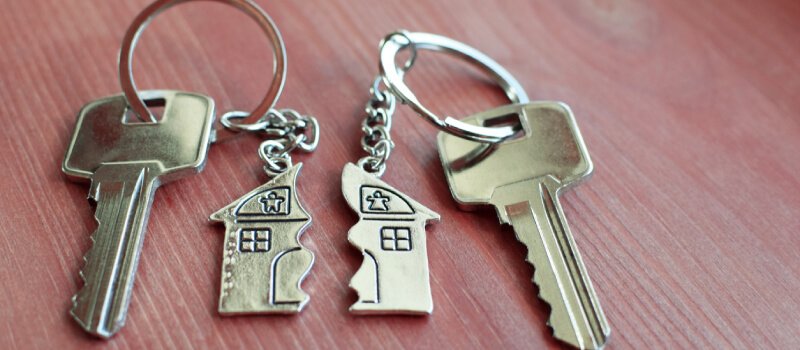 two sets of keys with half house keychain on each
