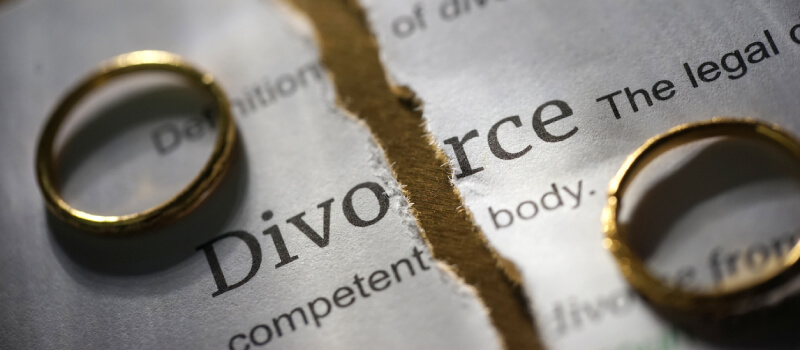 Divorce paper ripped in half, rings on either side