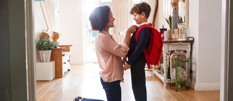 stepmother adjusting stepson's uniform