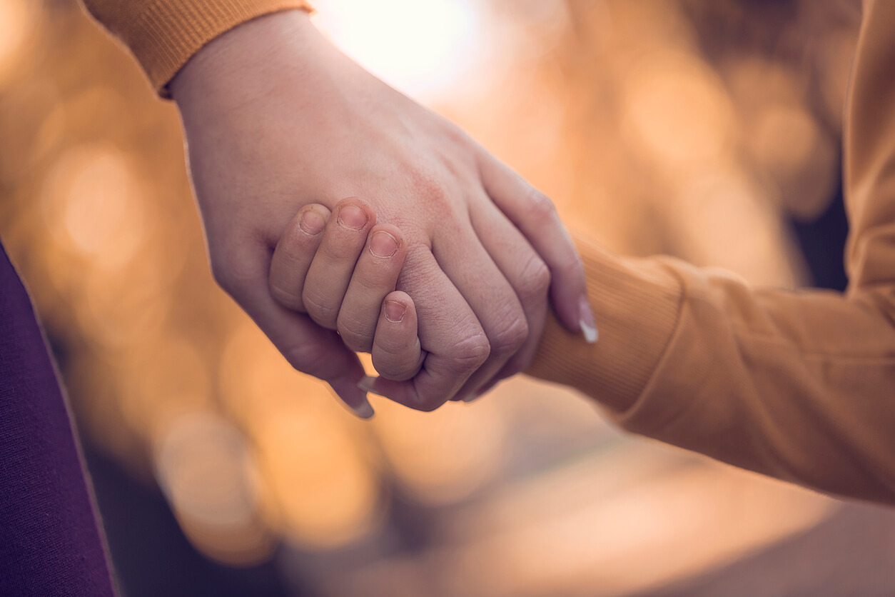 Woman holding child's hand.