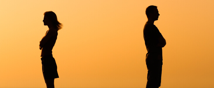 Woman and man standing close to each other, but facing opposite directions