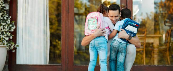 Dad hugging two children.