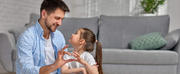 Father and daughter playing on floor.