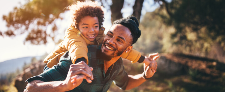 Father with son on his shoulders enjoying the outdoors.