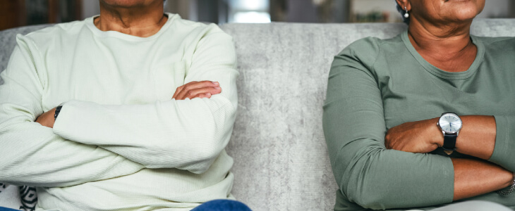 Legally separated couple sitting away from each other with arms crossed