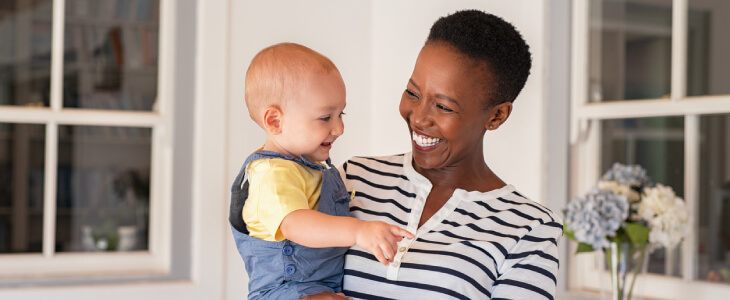 Mother holding adoptive child smiling