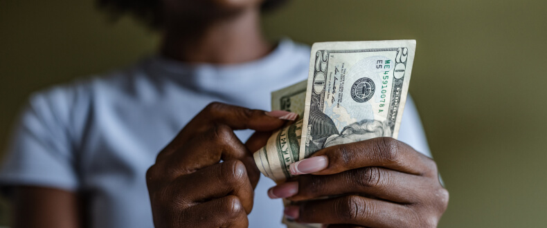 Woman counting 20 dollar bills