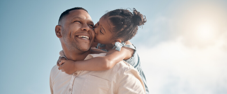 Father holding young daughter on back