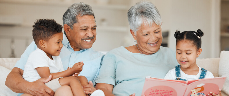 Grandparents reading a book to their grandchildren