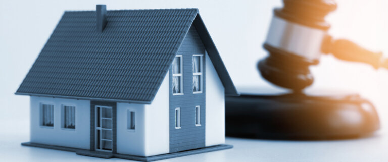 Model house beside a judge's gavel, symbolizing property division.
