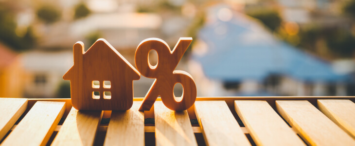 Wooden cutouts of a house and percentage sign