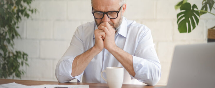 Older man looking stressed while reviewing documents