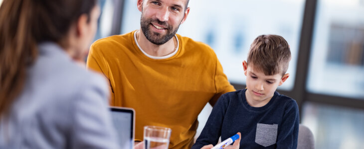 Father smiling with his son while talking to a paternity lawyer