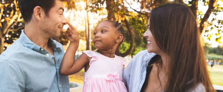 Multi racial family with adoptive children spending time together at the park