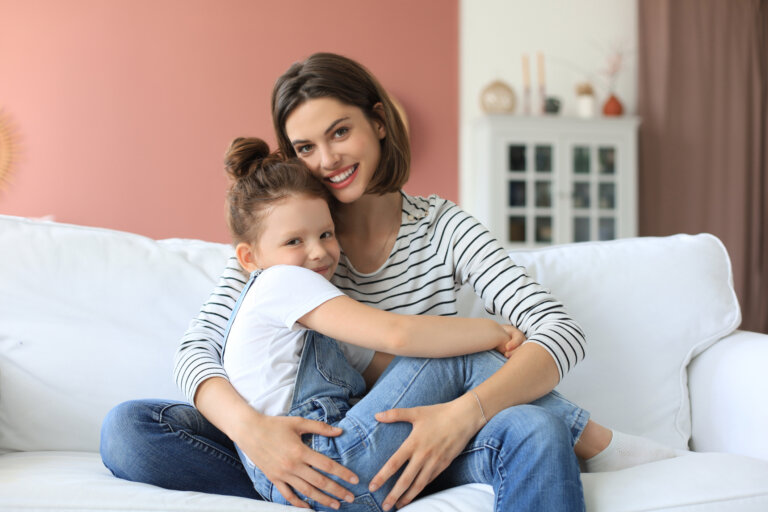 Happy loving mom hugging little daughter